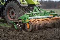 Tractor pulling a disc-er in a field